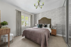 Furnished bedroom with double bed, mirrored wardrobes, curtains and light fitting. New homes development by Matthew Homes.